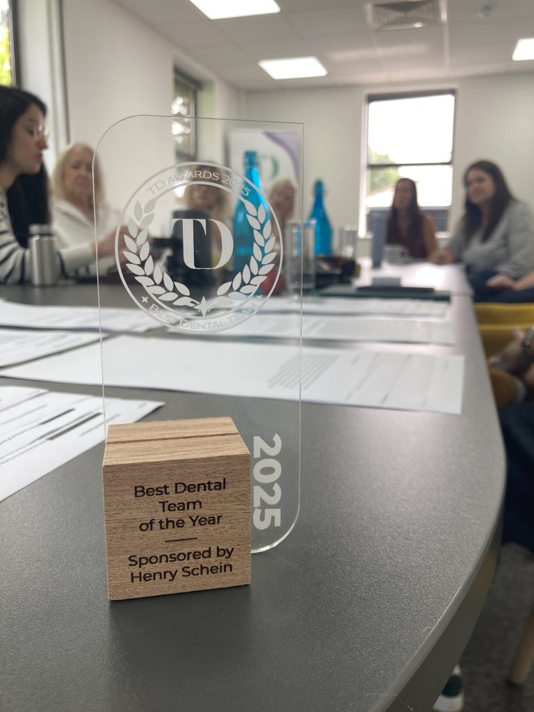 TD Awards 2025 Trophy placed on table in focus with award submissions and judges discussing in the background
